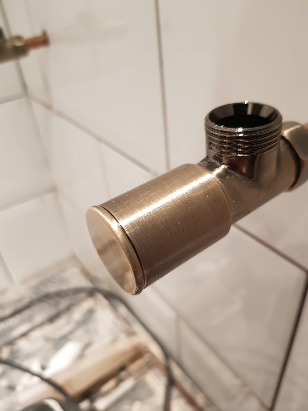 Close view of a brushed metal plumbing fitting