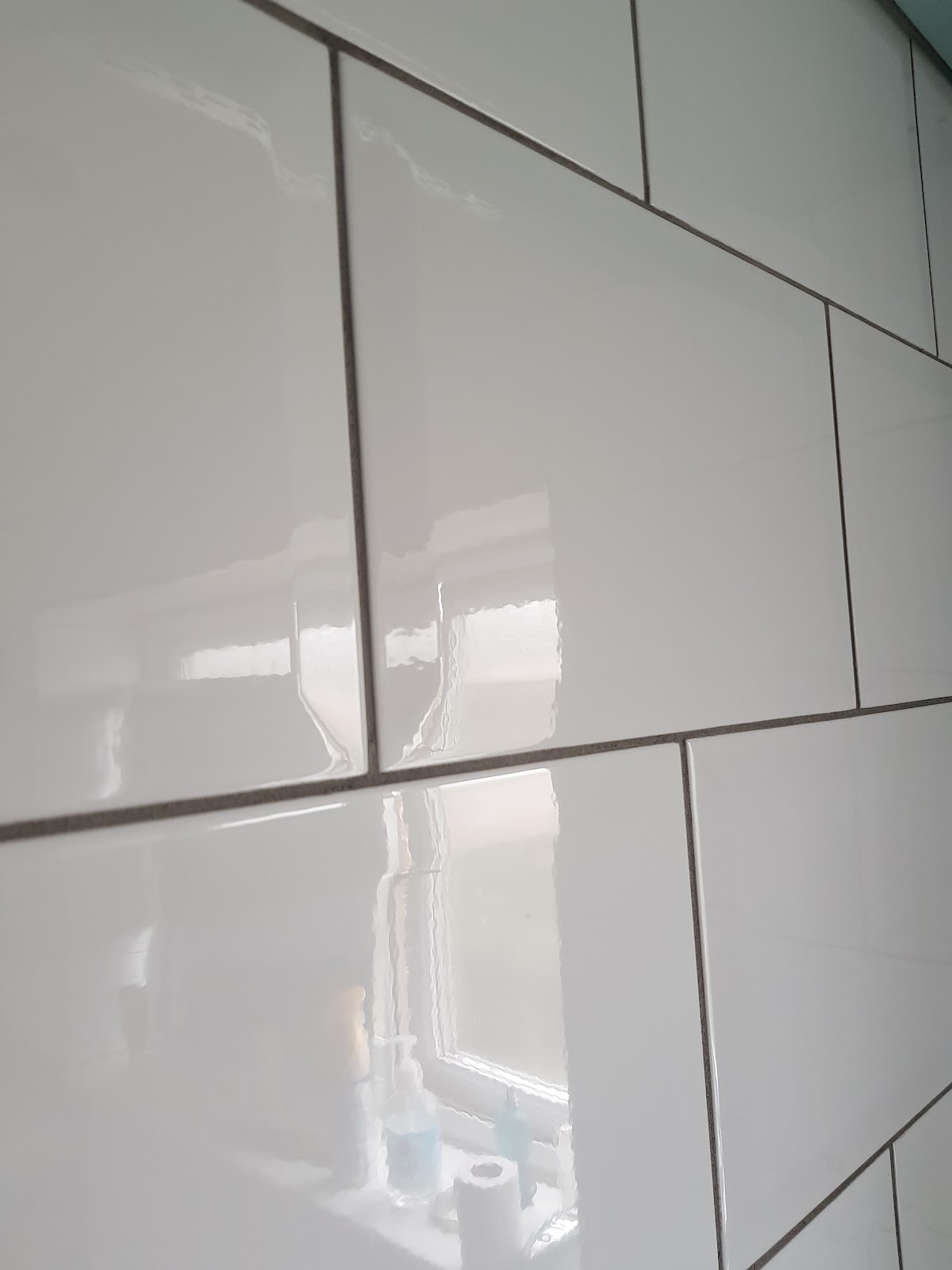 Close view of aligned white bathroom tiles and grout lines